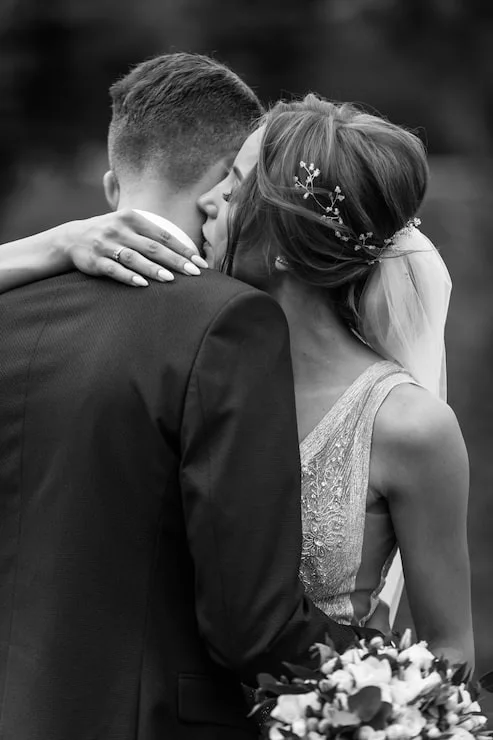 A wedding couple embracing in black and white
